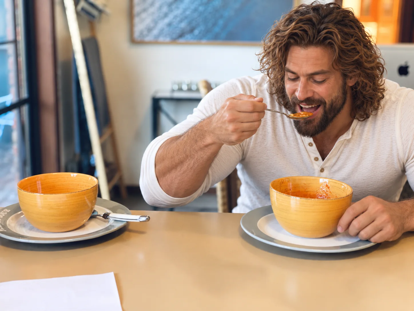 Husband having soup at the table, with a second bowl waiting